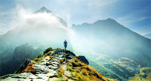 Man standing on outlook viewing mountain